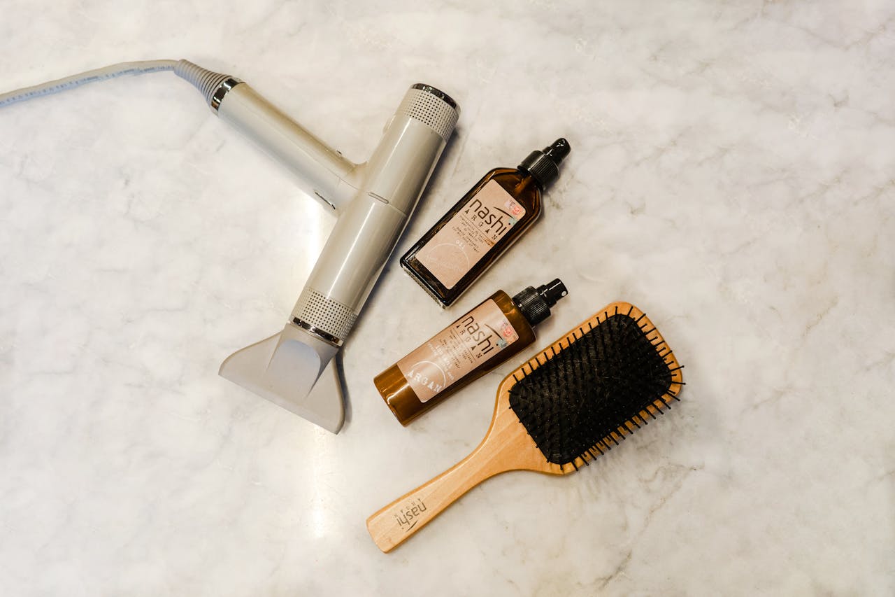 The Art of Drawing Readers In: Your attractive post title goes here Flat lay of hairdryer, hairbrush, and styling products on a marble table.