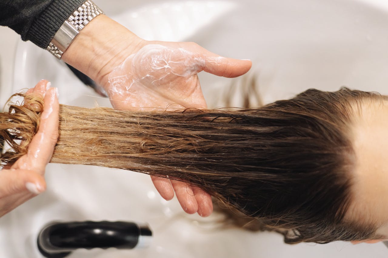 about-us-01 Close-up of a professional hair wash in a salon setting, highlighting hand technique.